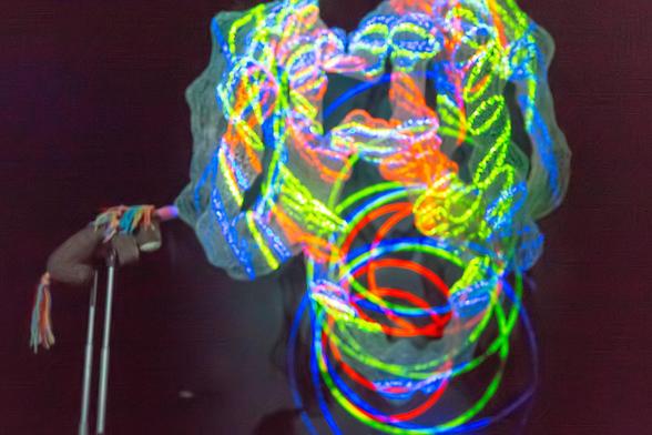 Max, das bunte Strickhorn, schaut von dem ausgefahrenen Griff eines Koffers auf eine bunt beleuchtete Drahtinstallation. Von der Webseite:

In dieser Sonderausstellung zeigt das Künstlerteam Well Wired Team um Kalle Maukel (Anfertigung), Werner Jarmatz (Licht) und Boris Vogeler (Sound) drei raumgreifende Drahtobjekte. Sie sind von Molekülstrukturen und Darstellungen sogenannter Elektronendichten inspiriert, die am European XFEL erforscht werden. Die Oberflächen der dreidimensionalen Drahtobjekte dienen dabei mehreren Projektoren als Reflektionsflächen.

Dabei entstehen plastisch anmutende, bewegte Motive, die einerseits den Molekülstrukturen und Elektronendichten entsprechen und andererseits angenehm graziös, fesselnd und beruhigend wirken.

European XFEL und das Well Wired Team wollen damit Unsichtbares sichtbar machen. Sie zeigen, wie aus einer Art „Dimensionssprung“ eines dreidimensionalen Körpers auf eine irregulär geformte (zweidimensionale) Projektionsfläche faszinierende neue Kreationen entstehen.

Begleitet wird die Installation von Klängen, die die Atmosphäre der künstlerischen Aktion unterstreichen, zugleich aber ein eigenständiges Element darstellen. Licht und Klang ergänzen sich und heben jeweils ihre Wirkung hervor.