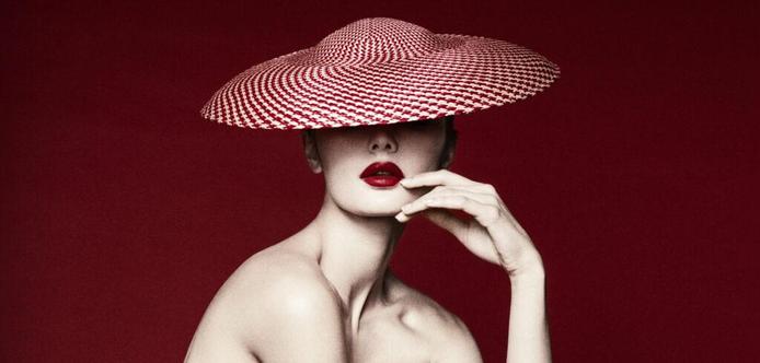 Renata Gubayeva wears a wide-brimmed red hat, photographed by Lindsay Adler.