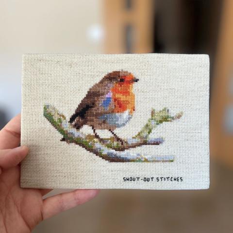 A robin red breast perched on a branch, cross stitch on rustic coloured aida fabric. A5 size.