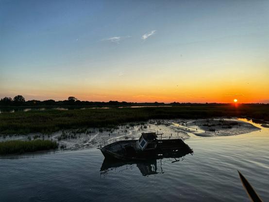Photo of a boat wreck, in Lignano Sabbiadoro, Italy.
Photo taken in the evening at sundown.
