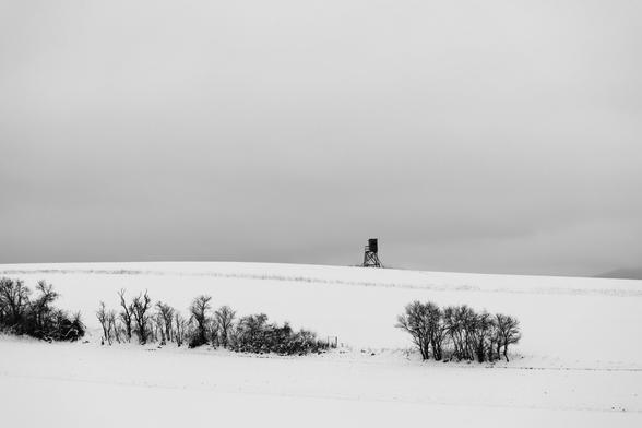Hochsitz am Horizont in Schnee Landschaft