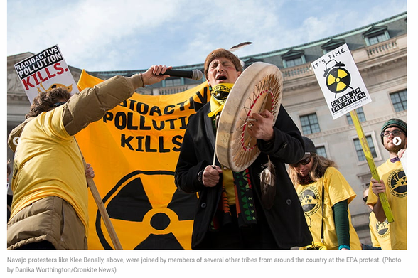 A man singing and drumming at a anti-nuclear rally. Behind him others holding banners and signs saying "Radioactive Pollution Kills:".
[Photo credit: Danka Worthington, Cronkite News]