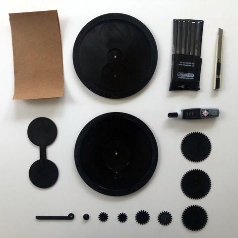Physical moon phase calculator, 3d printed parts, gears and tools on a white table.