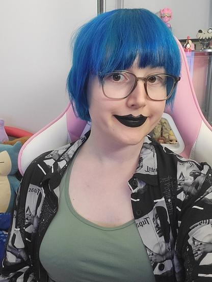 Revy with short blue hair
She's wearing glasses
black lipstick.
A 2pac shirt, and a sports bra