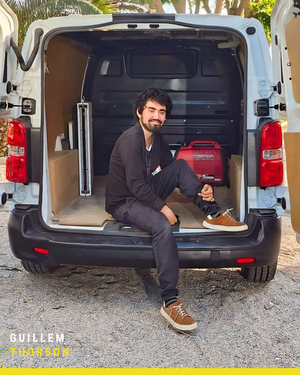 Guillem Thorson assegut al maleter d'una furgoneta equipada per a producció audiovisual, amb un generador Honda i materials de treball. Fotografia exterior amb llum natural i elements que reflecteixen l'entorn professional de rodatges i logística cinematogràfica.