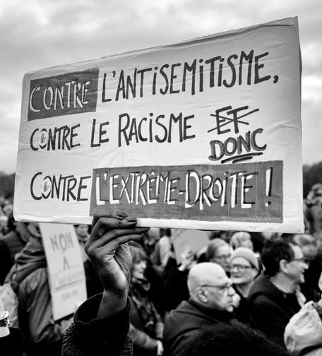 Photo de Serge d'Ignazio montrant une pancarte où il est écrit : "Contre l'antisémitisme, contre le racisme, donc contre l'extrême droite"