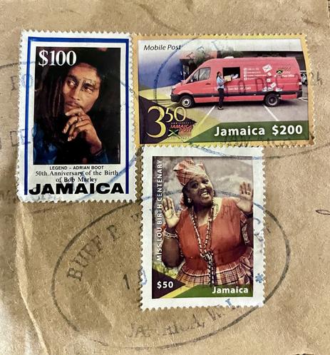 Three stamps on brown paper. Top left, Bob Marley 50th anniversary of birth; top right red post office van; bottom right an animated Miss Lou, 100th anniversary of  birth.