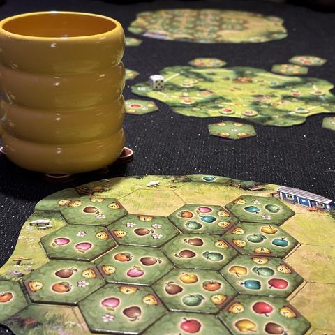 Applejack player board half filled with apples. Yellow tea mug, the central board and Eerko’s player board in the background.