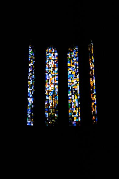 A contrasted shoot of a stained glass window in the dark from the inside of a church