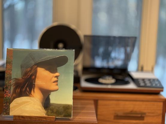 Louien - Every Dream I Ever Had LP cover.

A shoulders-up picture of Live Miranda Solberg - Louien - wearing a baseball cap, looking to the right.

The black LP plays on a vintage, restored Bang & Olufsen Beogram 8002 linear-tracking turntable to the right.
