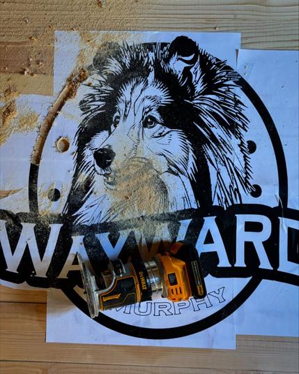 Paper with a print of a logo for wayward Murphy glued to a board with part of it routed out
