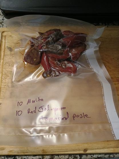 A clear vacuum sealed bag with red peppers in it.