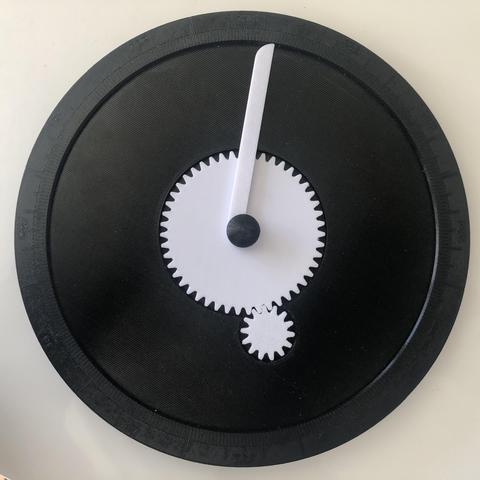 Physical moon phase calculator, made out of 3d printed parts and gears. The device is black and round, with a white calendar pointer on one side and a moveable moon phase indicator on the other.