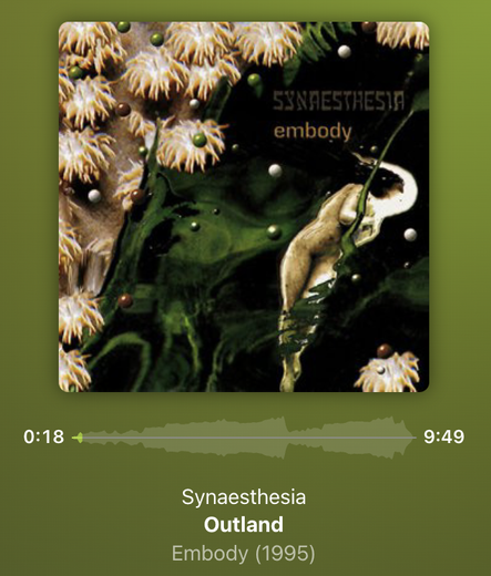 Screenshot of music player. Album cover for Synaesthesia's album "embody". It's abstract, but looks like some sea anemones and dark green "floor" with solidly colored balls floating in the space in front of it. They are green, white, and brown. It also looks like a naked person is floating to the right of most of the anemones and floating balls.