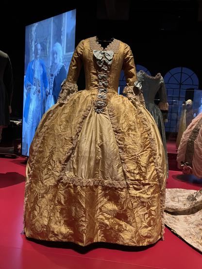 A Marie Antoinette inspired peach gold coloured silk dress on display