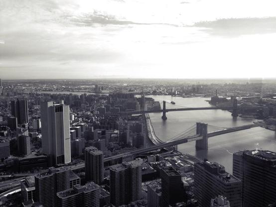 Black and white photo of New York from a skyscraper towards the Brooklyn bridge