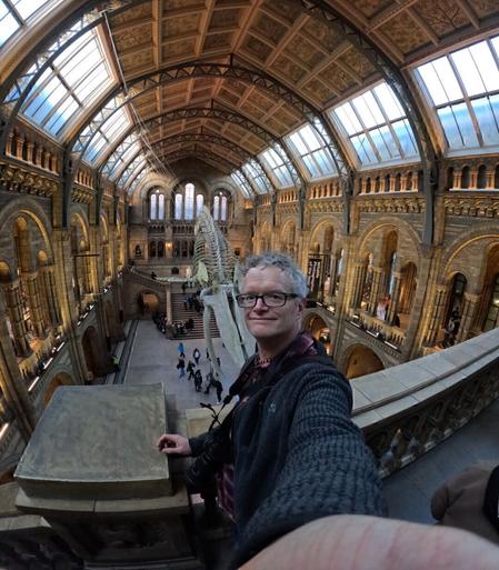 Wide angle selfie of middle aged man in the great hall of the natural History museum in London