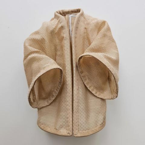 Picture of an offwhite shirt shaped like a kimono with a light fabric.