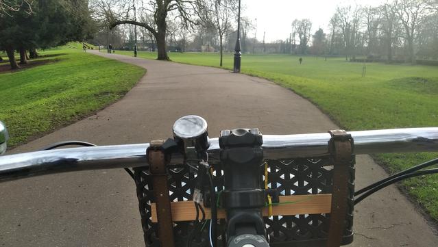A cycleway along the embankment of the old town wall, viewed over handlebars and basket