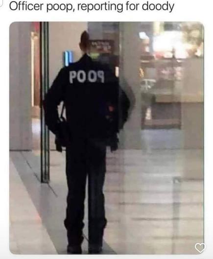 A cop standing besides a mirrored wall so that his back reads POOP