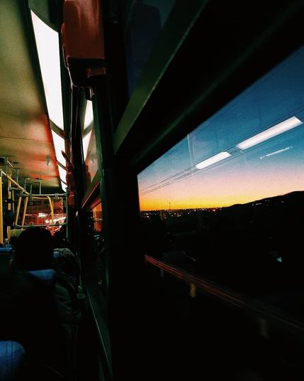 A sunset viewed from the window of a bus.