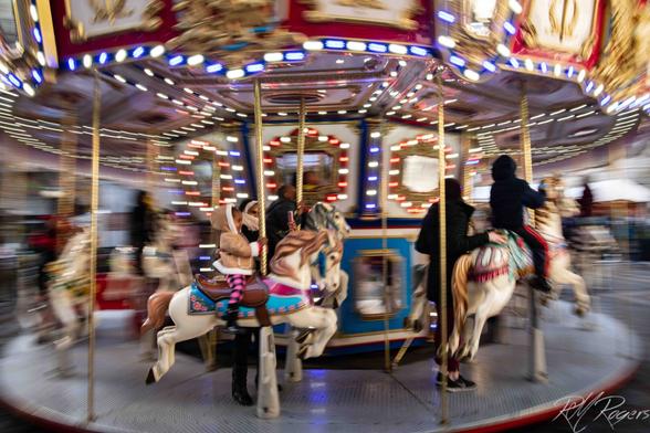 A mother and child whirl by on a colorful carousel in Seattle.