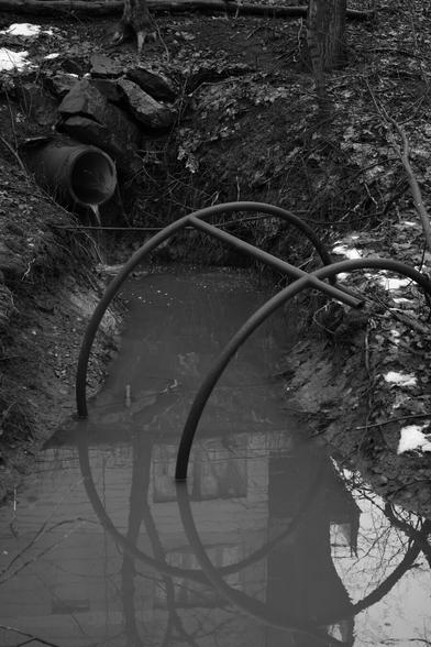 A photo of a sewer pipe and bent steel bars.