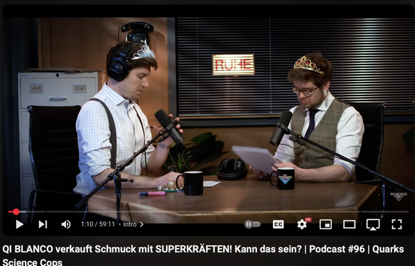 screenshot vom Quarks Science Cops YouTube Video Podcast #96, zu sehen sind die beiden Science Cops mit Plastikkrönchen im Haar, beide sitzen am Tisch mit Mikrophon und Kaffeetassen.