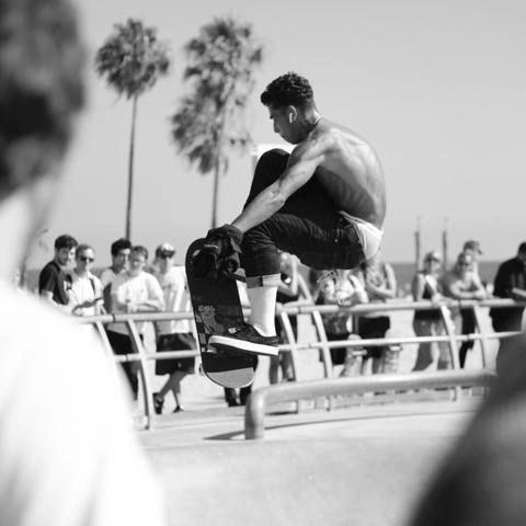 Black and white photo of a skater in a skate park doing a trick.