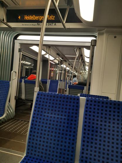 S-Bahn Wagen von innen, recht leer. Anzeige "Heidelberger Platz"