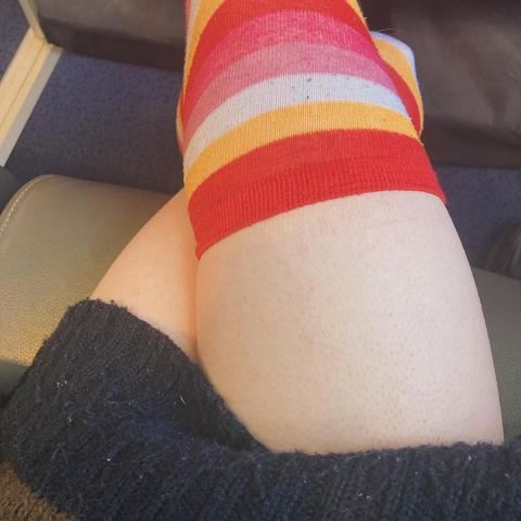 Samantha's Thighs coming out of large wolly jumper with thigh high socks thare coloured like the lesbian flag