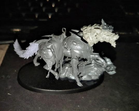 A kitbashed miniature using parts from the Lyrior Uthralle model from Games Workshop combined with the Feral Warpwolf head from Privateer Press to make an armored wolf mount in the Lumineth Realm-Lords atheistic.