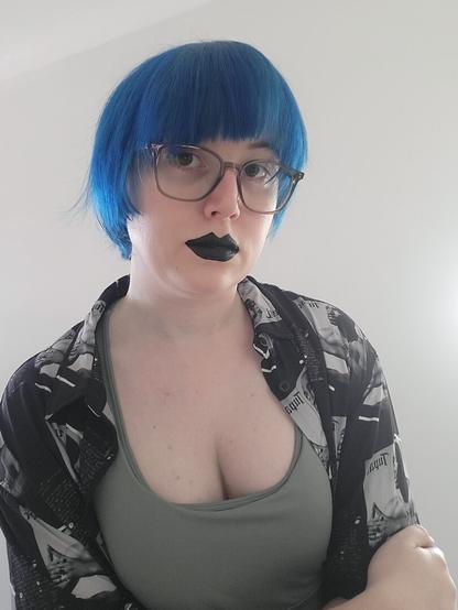 Revy with short blue hair and wearing a sports bra & a tupac shirt.
And wearing glasses & black lipstick