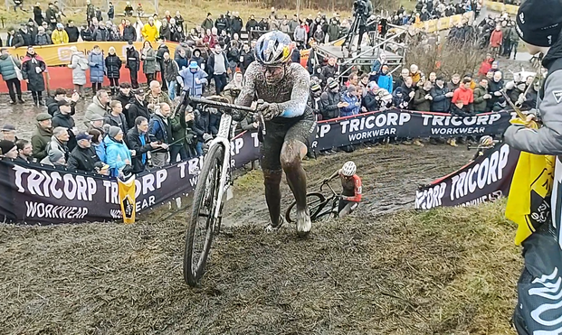 Cyclocrosser pushing her bike up a ramp