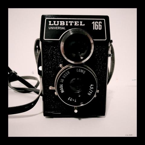 Farbfoto einer Mittelformatkamera der Marke Lubitel - Twin Lens Reflex, hergestellt zu Zeiten der UDSSR. Eine schwarze Box mit zwei übereinander angeordneten Linsen. Um die untere Linse angeordnet sind die Bedienelemente und Angaben zur Linse. Aufgenommen mit einem Sony Xperia Z5 und Vignette for Android.