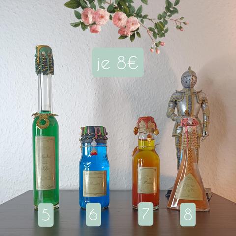Four with colourful liquid filled bottles stand on a table. In the back is a figurine of a knight in armor. 
Bottles (from left to right): 
1. Very large with long neck and filled with green liquid.
2. Filled with blue liquid, sealed with colourful wax and colourful pearls dangle from the lid.
3. Filled with orange liquid with orange pearls hanging from the lid. 
4. Filled with orange liquid. In the bottle are chains hanging from the cap.