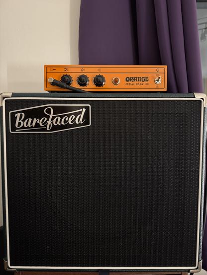 Orange Pedalbaby 100 guitar power amp sat on top of a Barefaced 1x12 Reformer cab.
