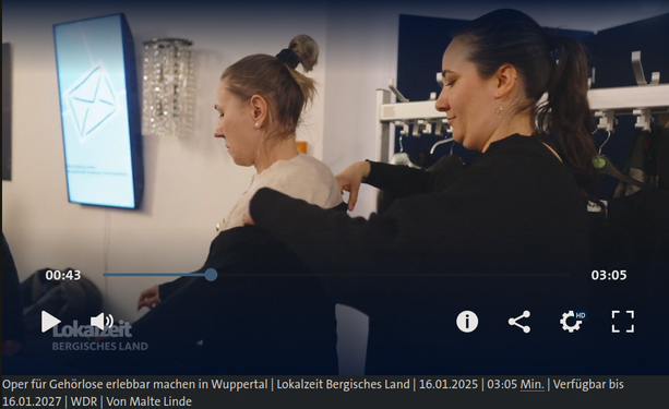 Still aus dem Bericht: Eine Opern-Mitarbeiterin hilft einer Test-Teilnehmerin in die Soundjacke
Untertitel: "Technik macht aus Musik Vibration
00:4303:05
Oper für Gehörlose erlebbar machen in Wuppertal
Lokalzeit Bergisches Land. 16.01.2025. 03:05 Min.. Verfügbar bis 16.01.2027. WDR. Von Malte Linde"