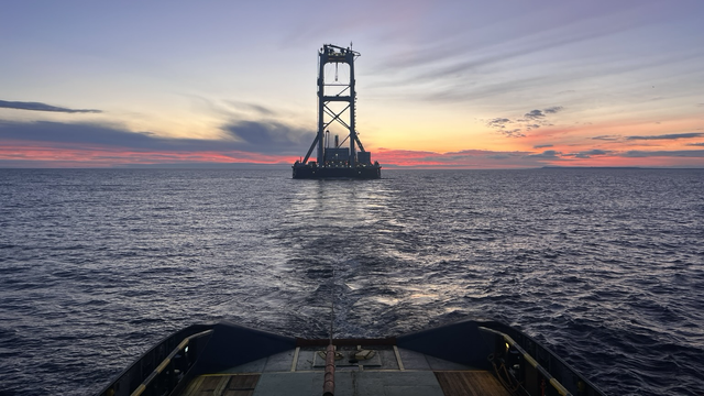 A very high towed object observer from the tug at morning twilight on a calm, rippled sea