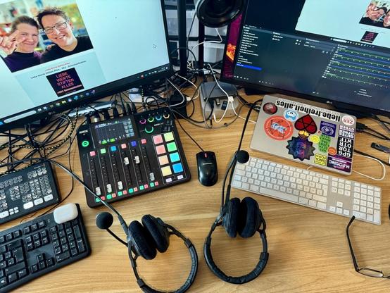 bild vom schreibtisch mit mischpult und zei headsets