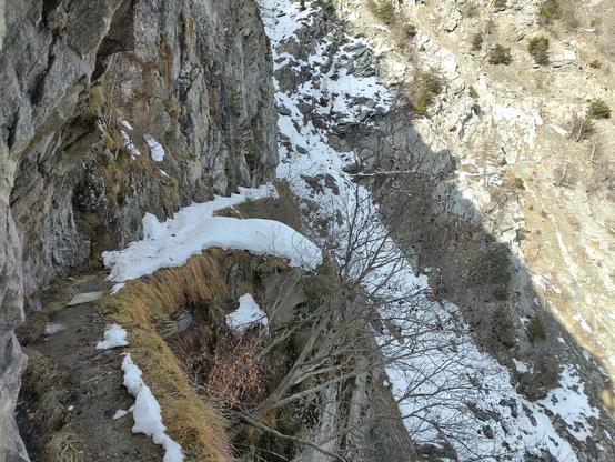 Ein schneebedeckter Pfad über einem Abgrund.