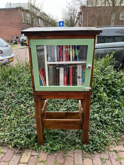 Wooden Little free library with a green door from the front
