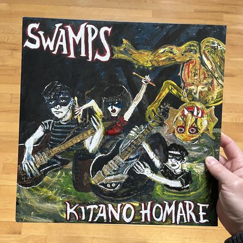 Album cover for Kitano Homare by Swamps, featuring a rough illustration three people, two holding guitars and one holding drum sticks, and a swamp monster somehow hanging upside down.