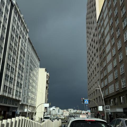 Cielo tormentoso al fondo de una calle con atasco de tráfico.