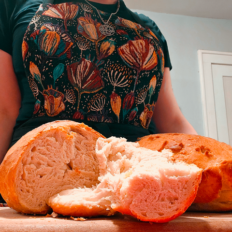 pixelnull herself in an adorable floral kitchen apron behind her homemade bread cut open