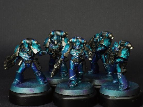 A 5 sized squad of headhunter space marines from the Alpha Legion. They're in metallic blue armour.