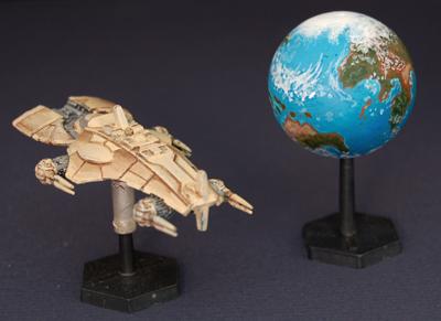 spaceship mini next to a painted terrestrial planet