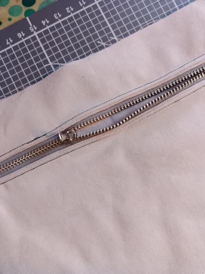 sand coloured fabric with a zipper pocket.