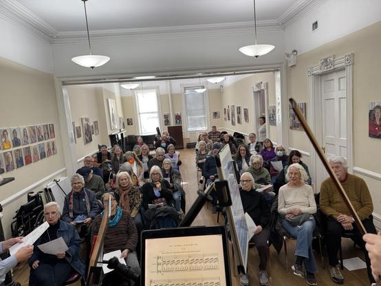 a photo showing a full house of audience at the Greenwich House, in New York City