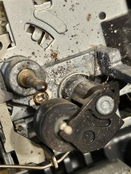 Closeup detail of the inside of a TASCAM 424mkII cassette mechanism, buildup of "dirt" around a pinch roller and capstan shaft.